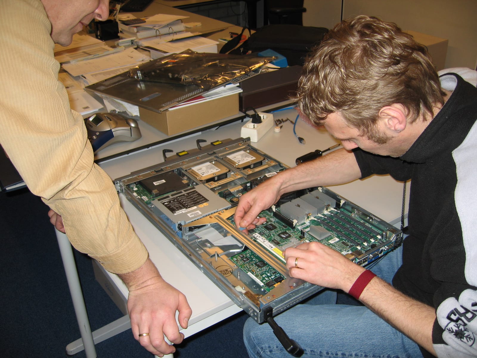 Technicians carrying out maintenance inside an open server